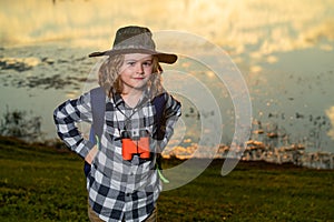 Child with backpack, traveller or explorer. Concept of exploration and discovery. Kid travel on nature outdoors