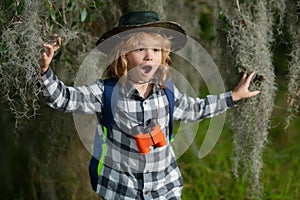 Child with backpack, traveller or explorer. Concept of exploration and discovery. Kid travel on nature outdoors