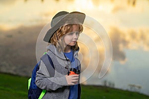 Child with backpack, traveller or explorer. Concept of exploration and discovery. Kid travel on nature outdoors
