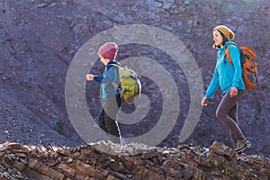 A child with a backpack walks in the forest with his mother