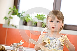 Child baking - little girl kneading dough