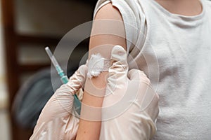 Child with bandaid on his shoulder after injection