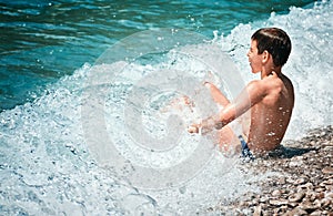 Child bathes waves surf Adriatik sea Lustica beach Zanjic Montenegro