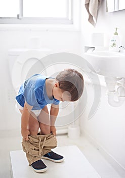 Child, bathroom and toilet training in diaper or learning growth, milestone or hygiene. Male person, kid and pants or