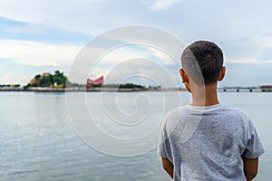 Child on the beach looking on the sea sunset