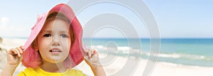 Child beach panoramic holding hat