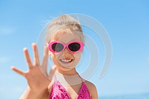 Child beach waving hand summer camp