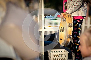 The child beats the tambourine. Child learning to play musical instruments