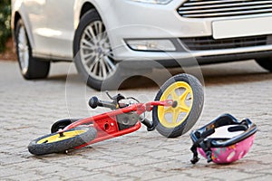 child bicycling helmet and bicycle near car during collision accident in the city