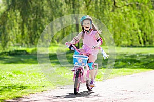 Child on bike. Kids ride bicycle. Girl cycling. photo