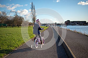 Child on the bike on the path by the river