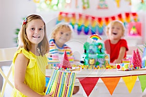 Child birthday party. Kids blow candle on cake