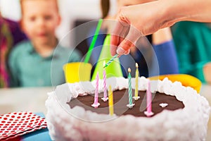 Child on birthday party prepared blowing candles on cake, selective focus