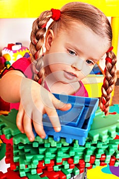 Child with block, construction set in play room.