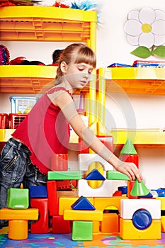 Child with block in play room.