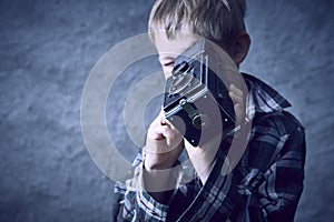 Child blond boy with Vintage photo film camera