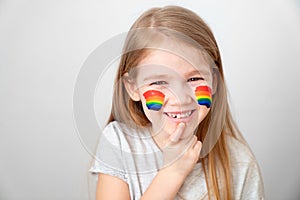 Child painted cheeks a rainbow. stay home. photo