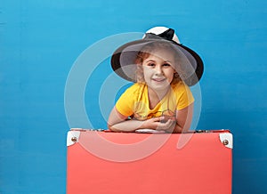 Child blonde girl with pink vintage suitcase ready for summer vacation. Travel and adventure concept