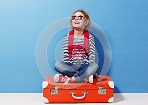 Child blonde girl with pink vintage suitcase ready for summer vacation. Travel and adventure concept