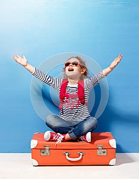 Child blonde girl with pink vintage suitcase ready for summer vacation. Travel and adventure concept