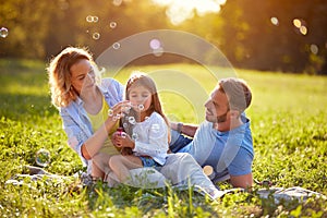 Child blow soup foam and make bubbles in nature photo