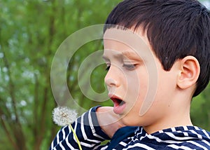 Child blowing dandelions