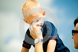 Child blowing nose. Boy with tissue. Catarrh or allergy