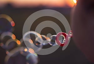 A child is blowing out soap bubbles