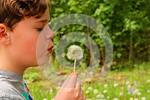 Child blowing at the seeds of a Dandelion