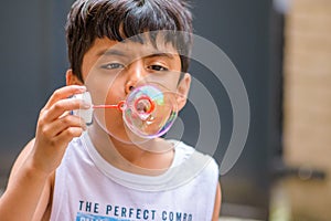 A child blowing soap bubbles; casual portrait