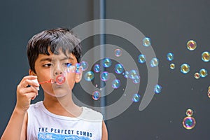 A child blowing soap bubbles; casual portrait