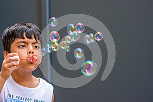 A child blowing soap bubbles; casual portrait