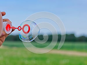 The child blows soap bubbles in nature.
