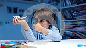 Child in blue clothes sitting at a table examines an animals bone