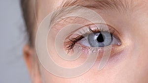 Child with blue eyes looking into camera, vision check, ophthalmology close-up