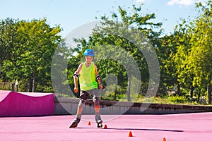 Child in blue helmet skate fast on rollerblades around cones