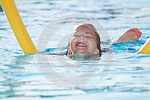 Child in blue water of the swimming pool. Girl, happiness.