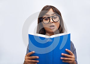 Child, book and reading for development in education, information and knowledge by white background. Girl, student and
