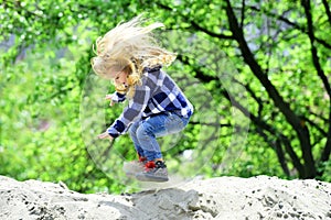 Child bounce on sand in spring or summer park