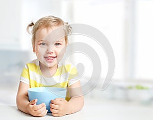 Child with bowl plate,kid`s nutrition.Girl eating