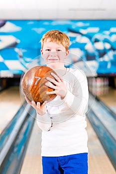 Child bowling with ball