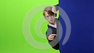 Child boy appears from the side of the board holding her hands in front on a green screen. Slow motion