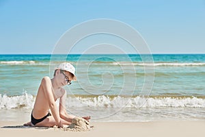 Child boy on beach. Rest on vacation, play in sand against sea. Tourism and vacation on ocean. Family vacation in summer. Vacation