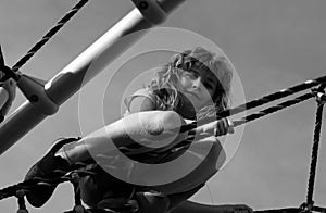 Child boy climbed on top of the rope web on playground. Little boy climbs up the ladder on the playground. Child climbs