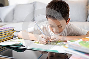 Child boy concentrate and focusing on studying,doing homework,writing,reading book,concentration in work,after treatment of photo