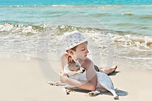 Child boy with dog jack russel on beach. Best friends rest on vacation, play in sand against sea. Tourism and vacation on ocean.