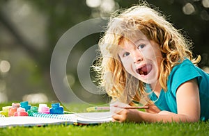 Child boy drawing in summer park, painting art. Little artist painter draw pictures outdoor.