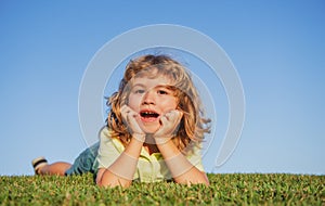 Child boy enjoying on grass field and dreaming.