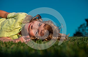 Child boy enjoying on grass field and dreaming.