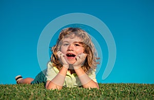 Child boy enjoying on grass field and dreaming.